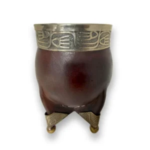 Mate imperial forrado en cuero legítimo color suela con virola superior ancha y base de cuatro patas de metal cinceladas sobre una mesa de madera.